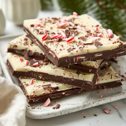 The Ultimate Gluten And Dairy Free Desserts For Christmas Everyone Will Love 5 No-Bake Peppermint Bark with Dairy-Free White Chocolate pieces stacked on a clean surface.