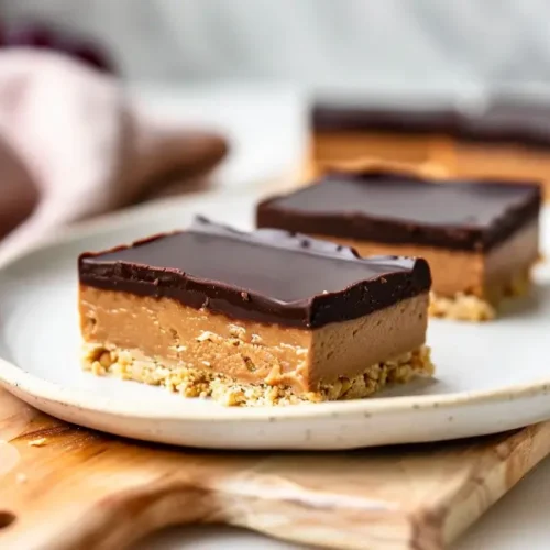 10 Irresistible Vegan Gluten Free Desserts You’ll Want To Make Again And Again 5 Close-up of no-bake vegan chocolate peanut butter bars with a smooth chocolate top and thick peanut-butter base.