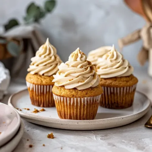 The Best Easy Gluten Free Thanksgiving Desserts for a Crowd 15 Frosted vegan gluten-free pumpkin cupcakes in warm natural light.